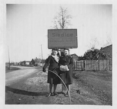 Siedlce women posing under sign